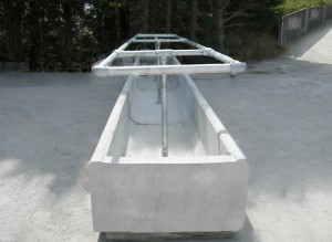 Double-sided precast concrete cattle feed trough with galvanised top frame by West Country Concrete Products, Devon