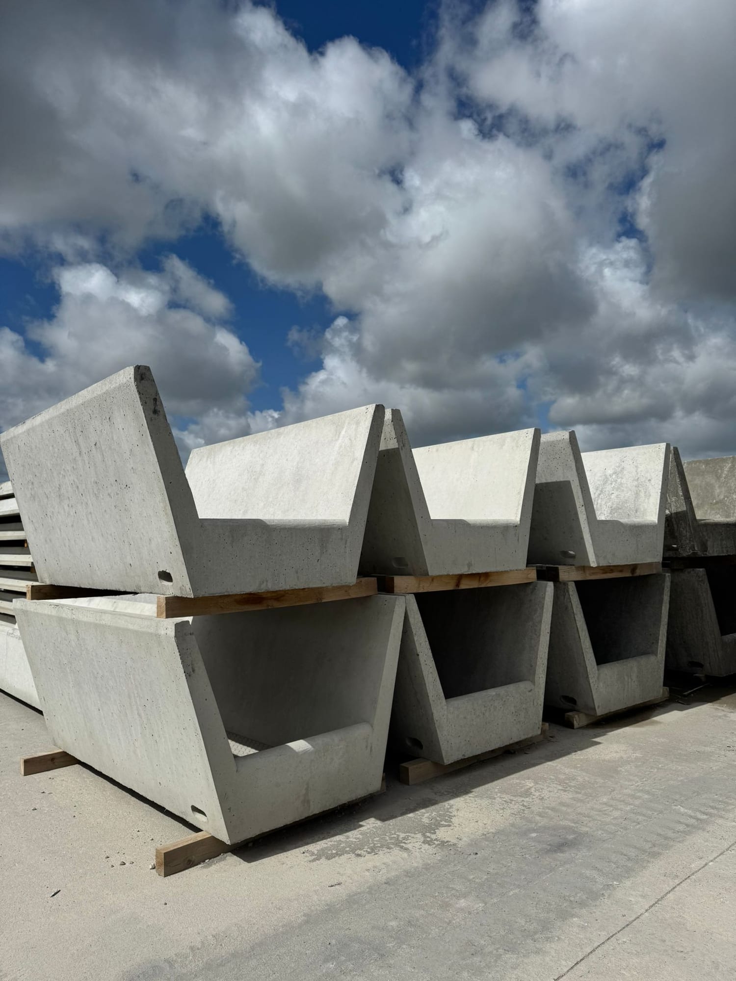 Close-up front view of V-shaped precast concrete feed troughs showing triangular cross-section profile at WCCP Devon