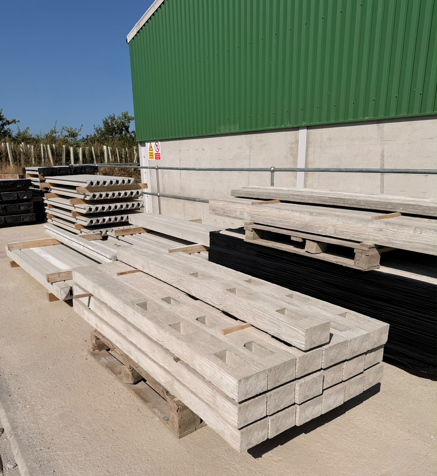 WCCP precast concrete fence posts, wood-grain finish, stacked at the Holsworthy yard