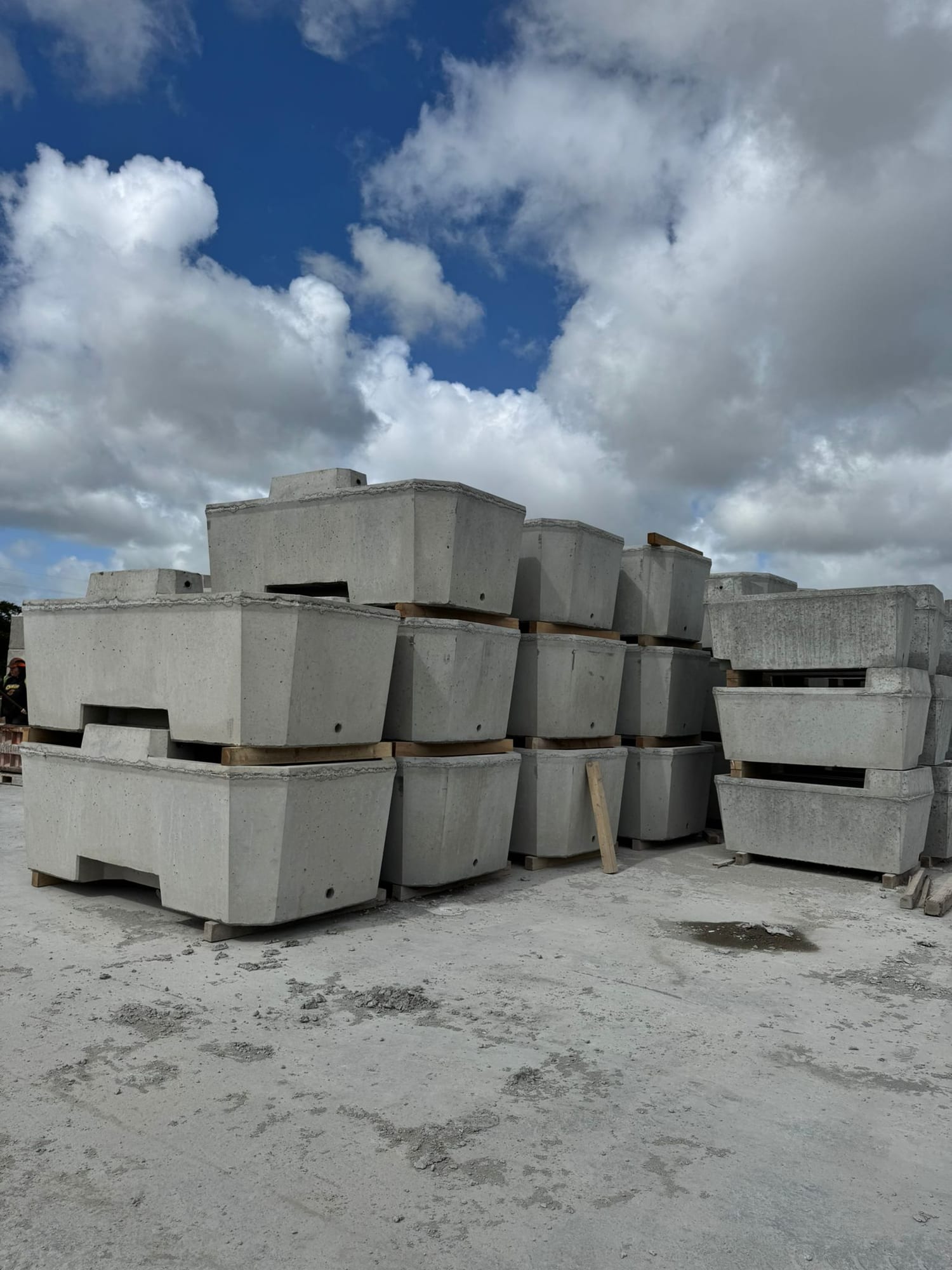 Wide view of precast concrete headwall and catchpit sections stacked in pyramid formation at the WCCP yard, Chilsworthy, Devon