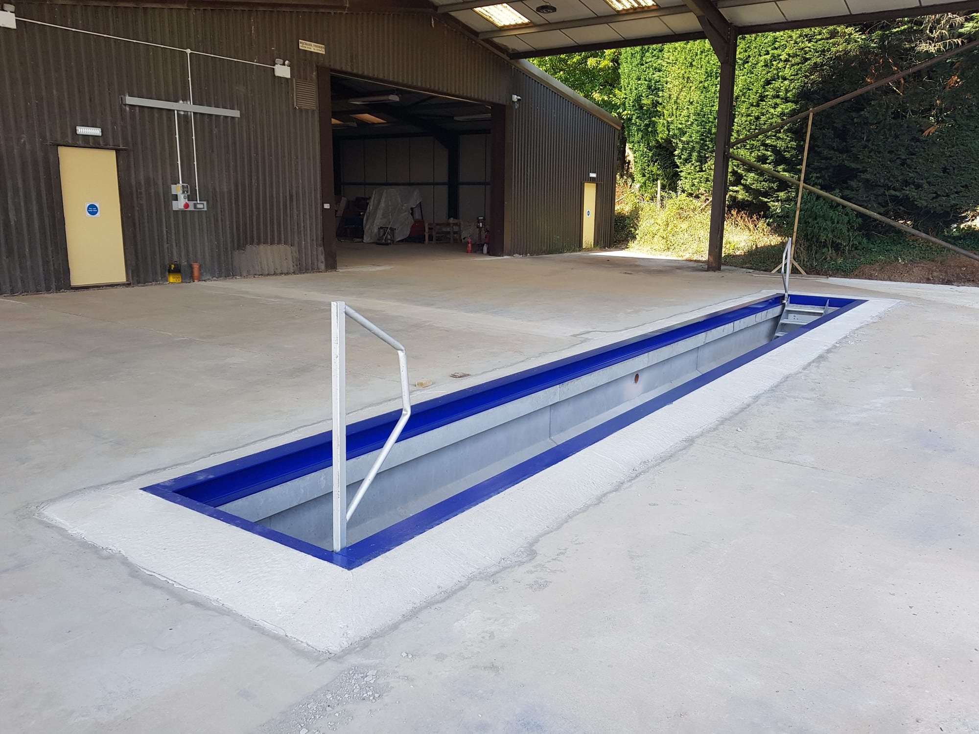 Installation of a WCCP precast concrete vehicle inspection pit in a commercial workshop, Devon