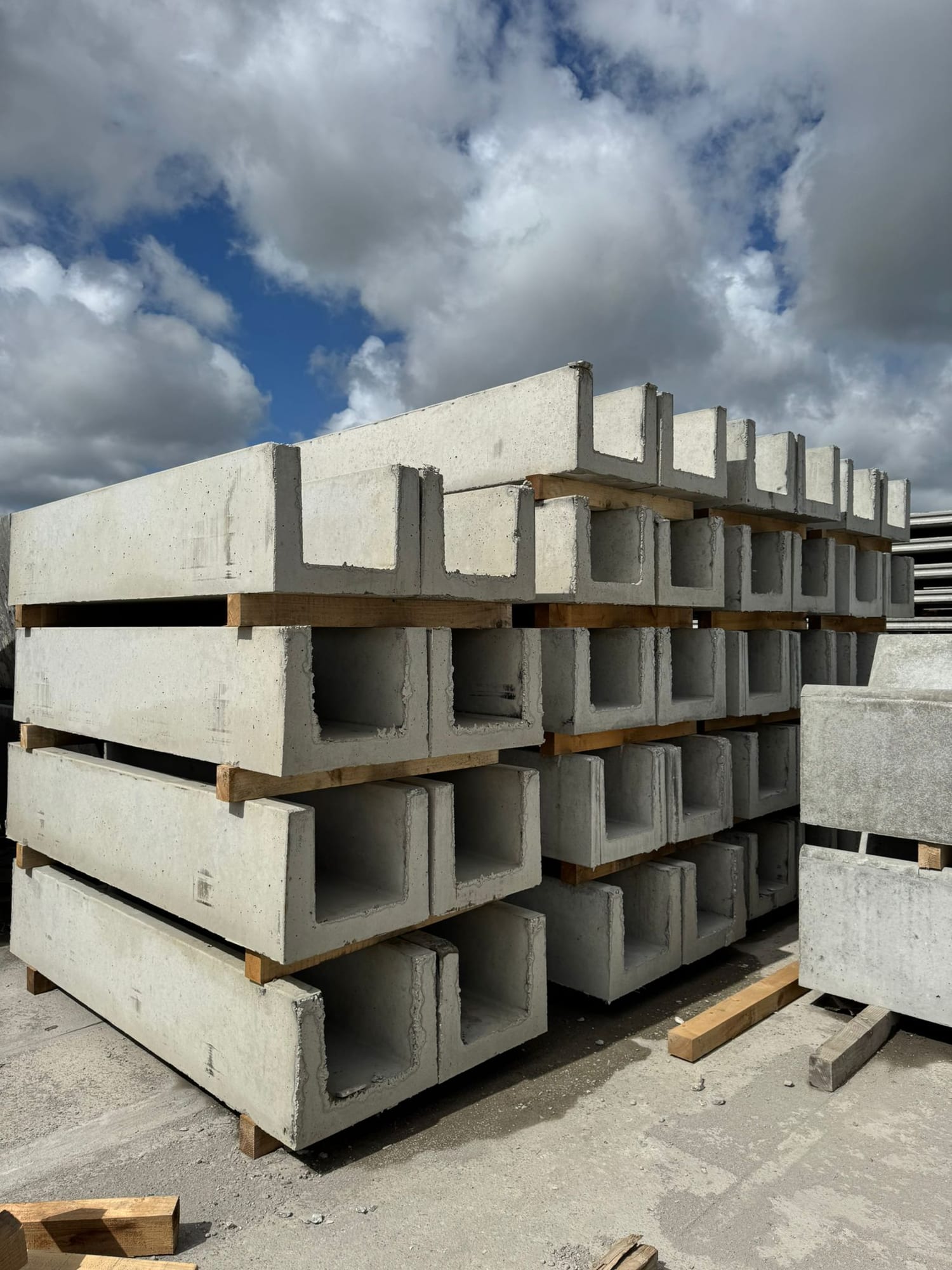 Close-up end view of precast concrete U-channel slurry sections showing wall thickness and internal profile at WCCP Devon