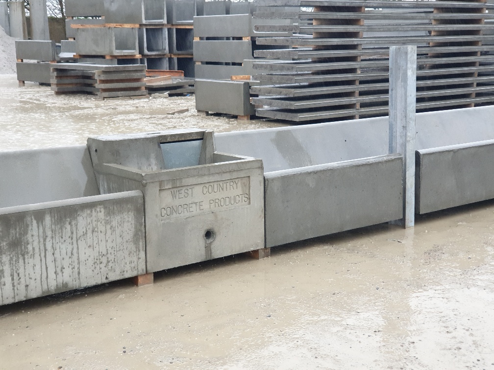 Row of inline cube precast concrete water troughs with J-trough notch-out and WCCP cast-in branding, Devon